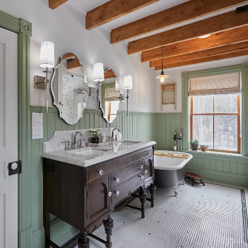 Sage renovated farmhouse bathroom with wooden vanity