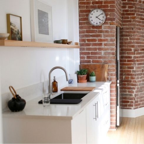 A clutter-free kitchen with a red brick wall