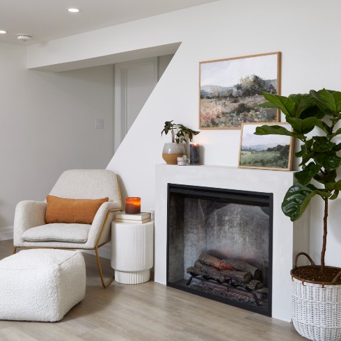 Basement studio apartment with a modern electric fireplace and seating area