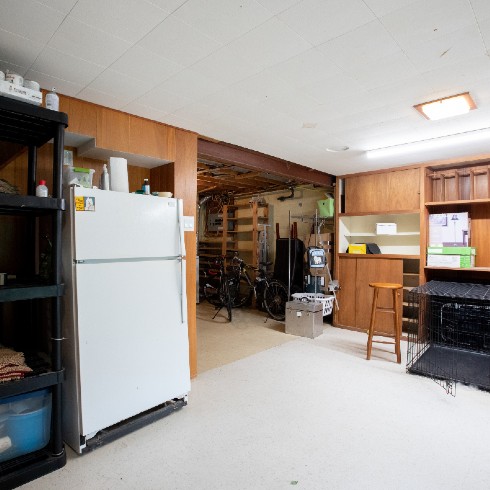 Old cluttered basement with dated paneling