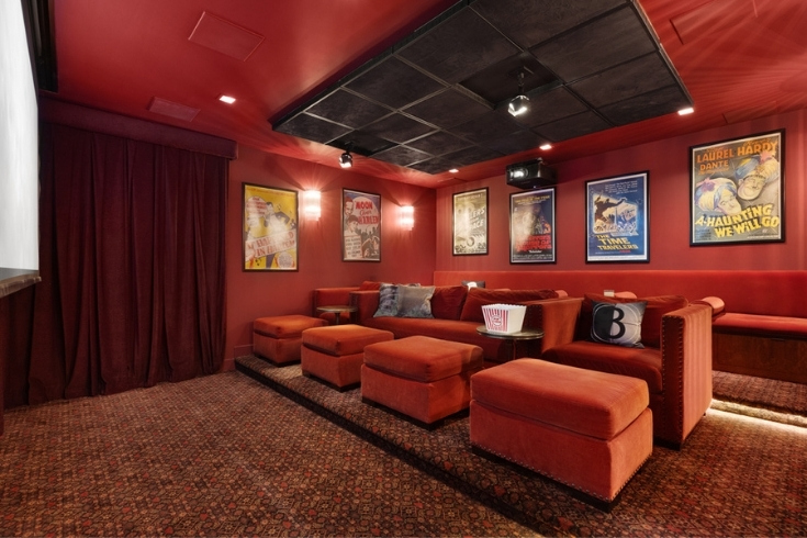 A home movie theatre with red lounge chairs