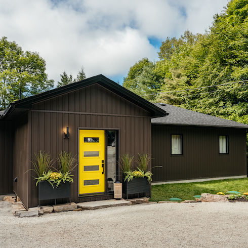 Dark cottage exterior with bright yellow door