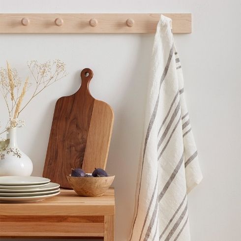 A linen towel on a wooden hook with wooden kitchen accents