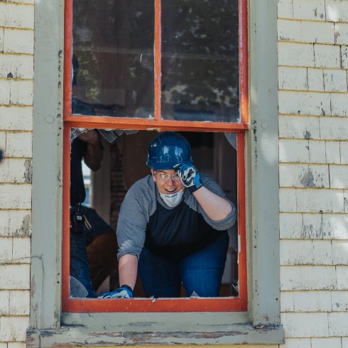 Mandy Rennehan leaning out window of Chester Street project