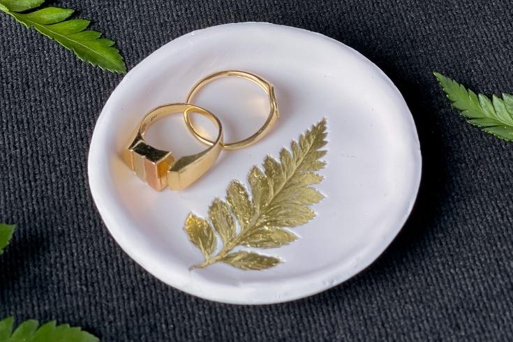 Two wrings on a white clay dish with a golden leaf 