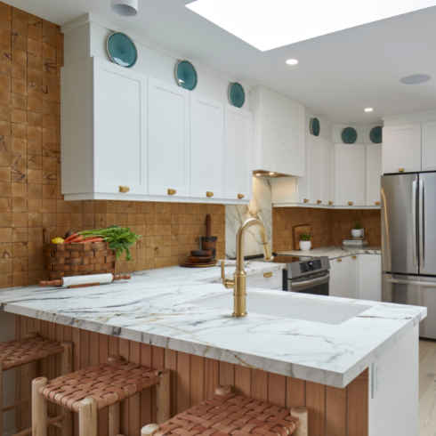Renovated kitchen with white cabinetry and countertop seating