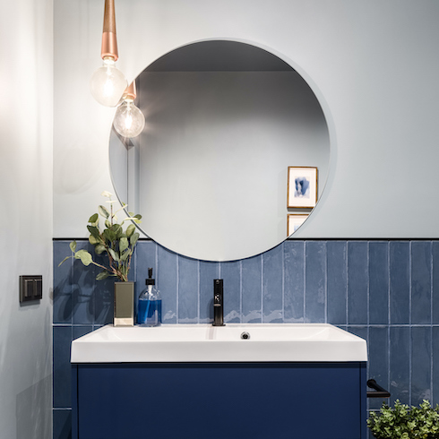 Designed bathroom with stylish blue cabinet and blue wall tiles