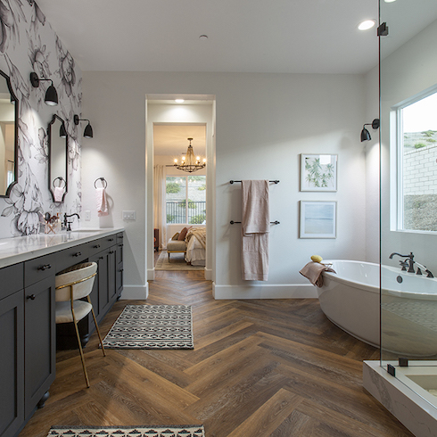 HGTV star Mina Starsiak used a herringbone pattern wood floor, wall paper, a freestanding tub and custom shower to transform the master bathroom of her house, as seen on Rock the Block. (After)
