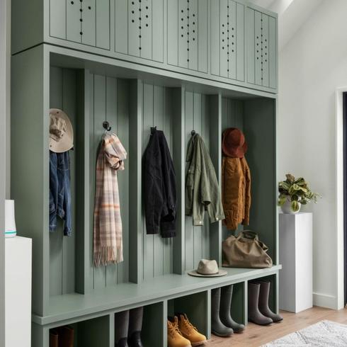 Green mudroom with shoe storage and coat hooks