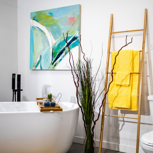 Bath tub with decorative ladder holding yellow towels
