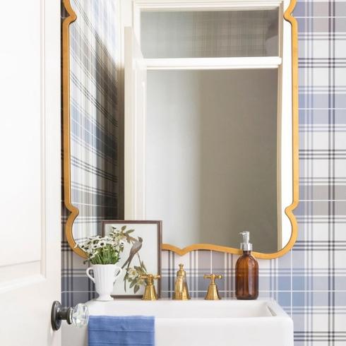 Powder room bathroom with blue plaid wallpaper and ornate gold mirror