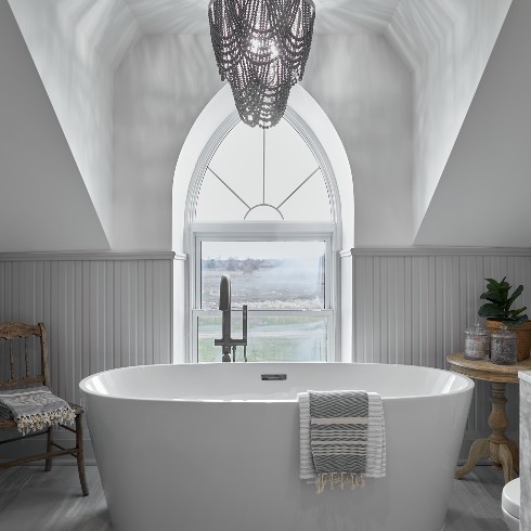 Standing tub in front of an arch window