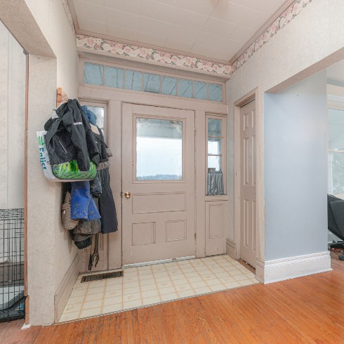 Entryway with small closet and drab tiles