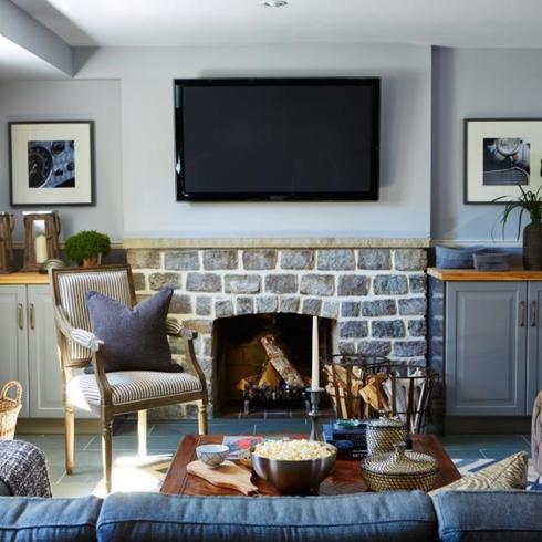Basement living room with stone fireplace and blue colour scheme