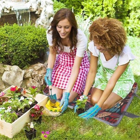 Two women on a kneeling pad gardening together.