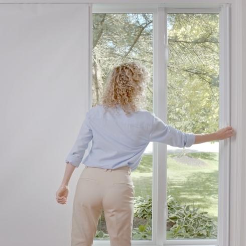 A woman closing her windows.