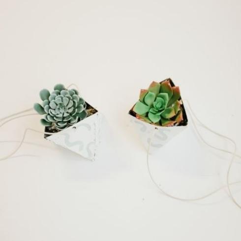 White origami planters with fake succulents.