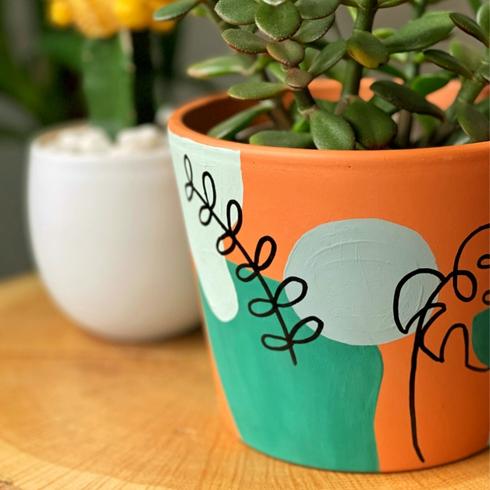 Hand painted terracotta clay pots with green abstract design.