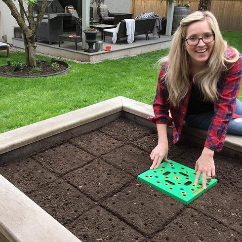 Woman using a seeding square in her garden.