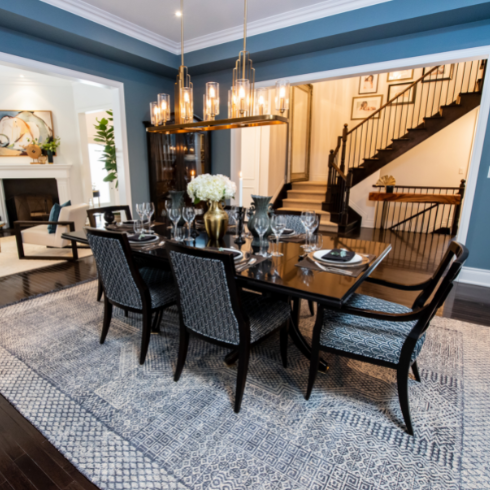 Blue dining room with large dark dining table and pendant light