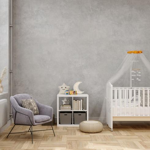 Gray nursery with white crib, white bookshelf and gray chair.