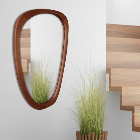 Wooden asymmetrical mirror on a living room wall.