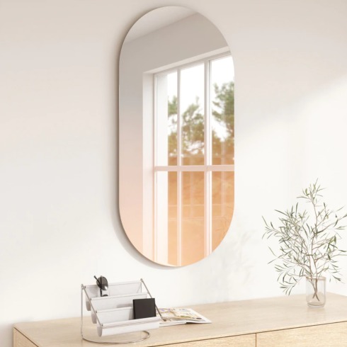 An oval-shaped mirror mounted on the wall.