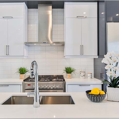 White kitchen with smooth cabinets and a silver kitchen sink.