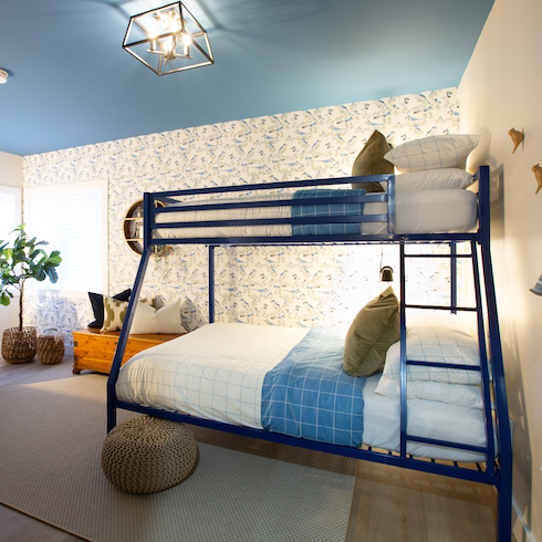 Kids room with a painted blue ceiling and a bunk bed with white and blue bedding