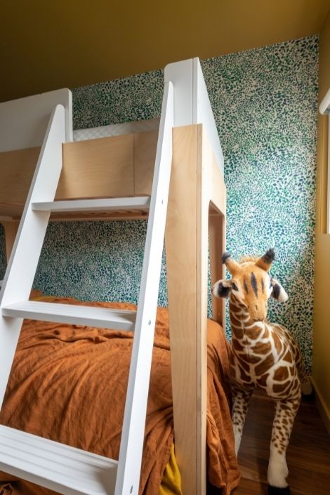 bunk bed, white ladder, green wall, stuffed giraffe