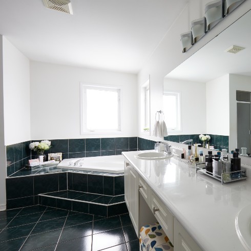 Dated bathroom with green tile and white sinks