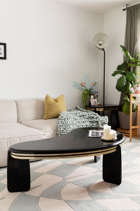 A black shiny coffee table in a tan sofa