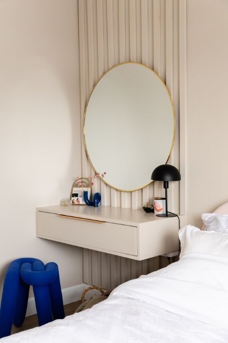Cream floating nightstand with a circular hanging mirror
