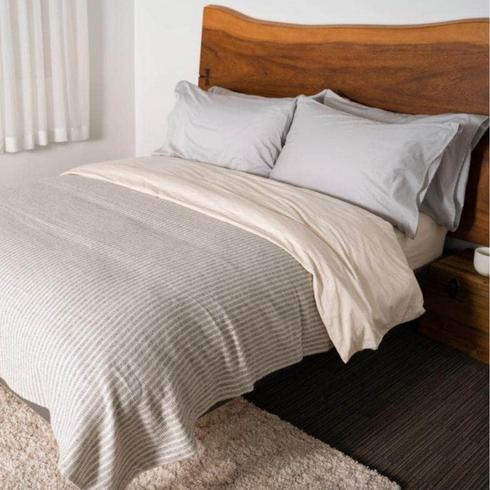Grey bedsheets in a wooden bed.