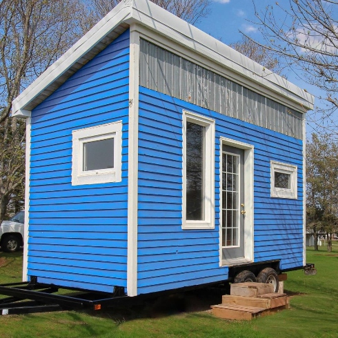 A tiny home with blue exterior and white trim