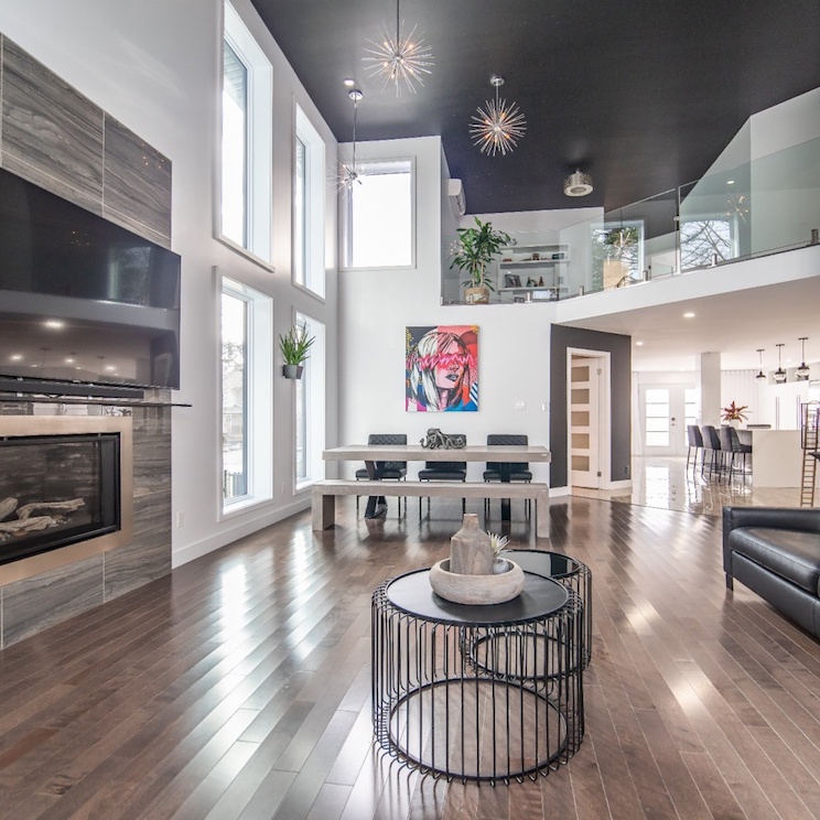 Modern home interior with dark wood floors, built-in fireplace and black painted ceiling