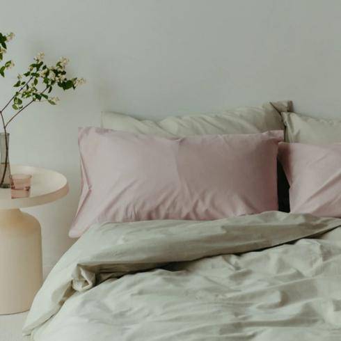 Sage green bedding in a bedroom.