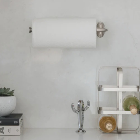 A sleek silver wall-mounted paper towel holder in a kitchen