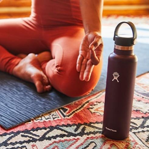 Reusable water bottle beside a person doing yoga