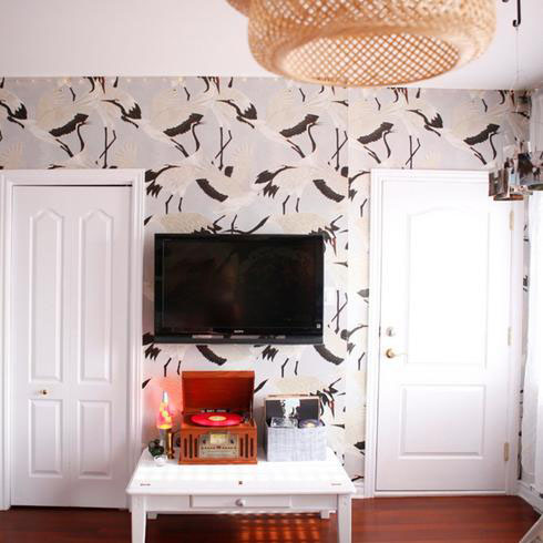 Den with TV, bird wallpaper and boho light