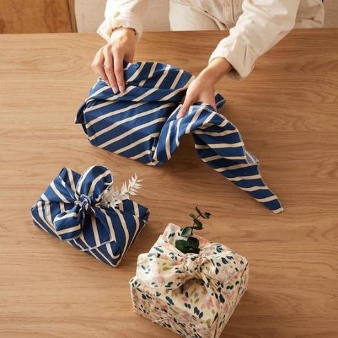 Person wrapping gifts in reusable gift wrap