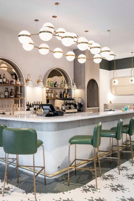 White lobby bar with green stools and modern fixtures