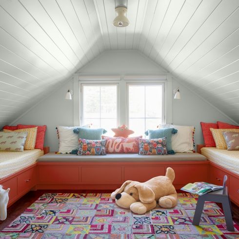 Kids' attic playroom with built-in toy storage benches