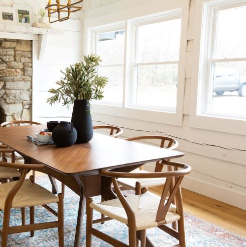 Light wood scandi style dining table surrounded by bright windows