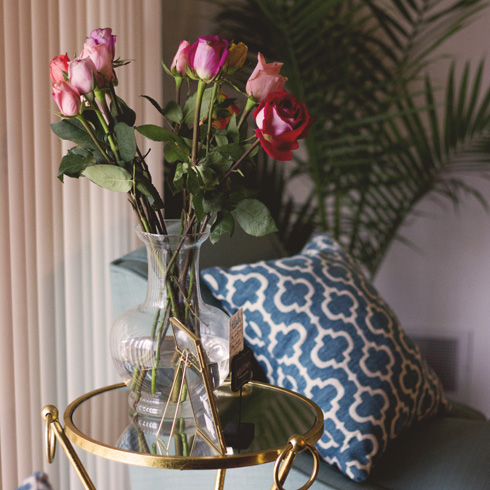 Vase of fuschia roses in an eclectic living room