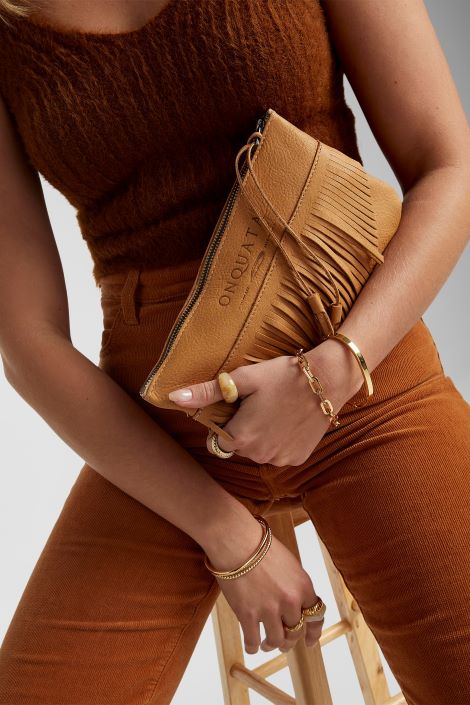Woman holding tan leather purse
