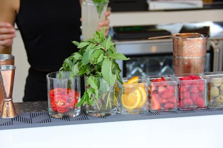 A garnish bar filled with different fruits and herbs.