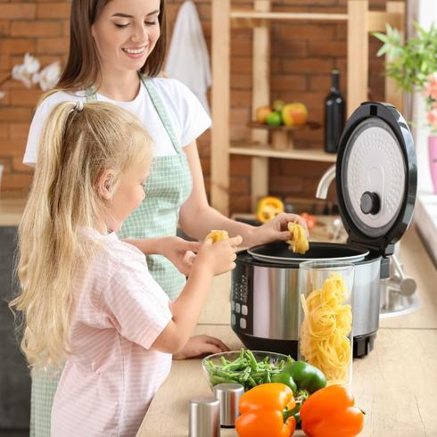 Mom and daughter making dinner in a pressure cooker