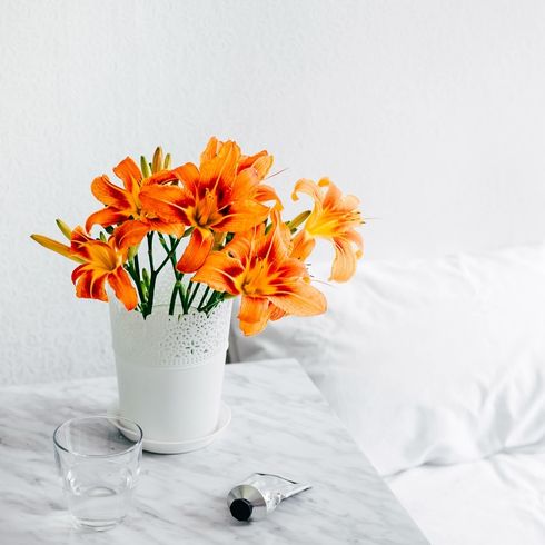 a white vase with orange flowers