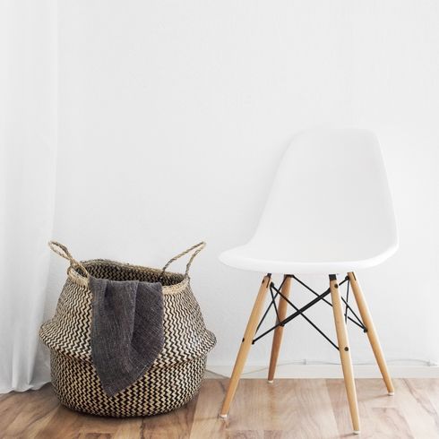 laundry basket beside a white chair